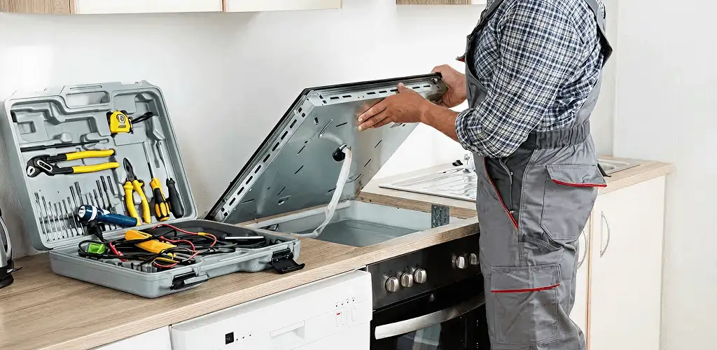 Handyman repairing a cooktop and checking wiring connections in Nashville, TN
