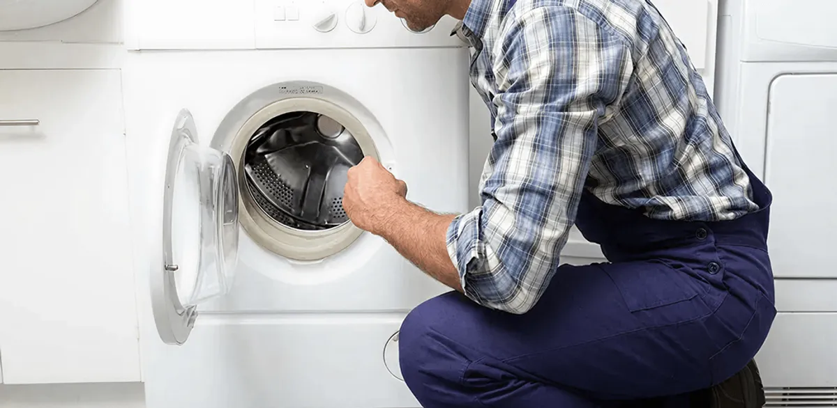 Handyman inspecting a dryer drum and internal parts for repair in Nashville, TN