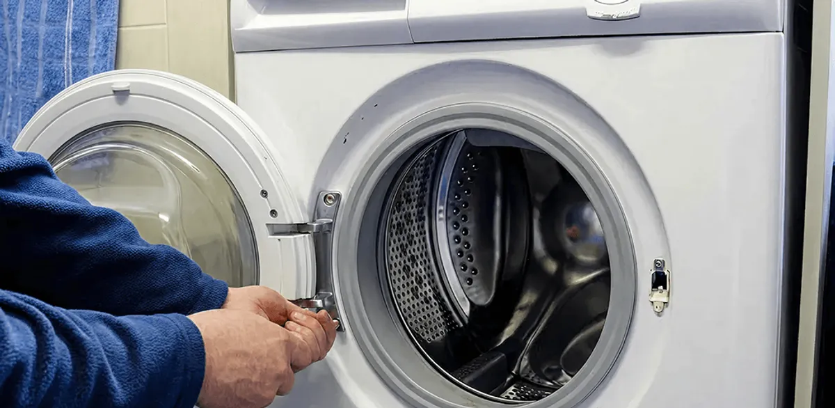 Washing machine repair handyman checking a front-load washer door and latch in Nashville, TN