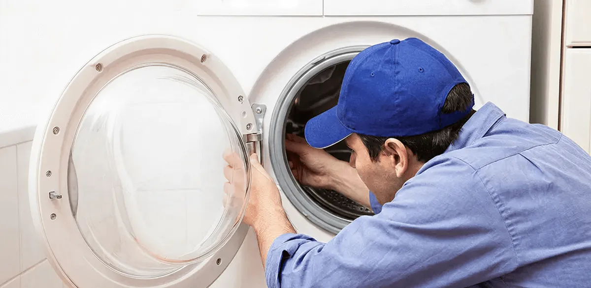 Washing machine repair handyman inspecting a front-load washer drum in Nashville, TN